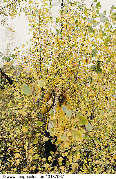 Woman standing amidst plants during autumn