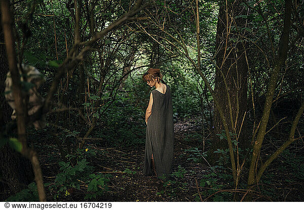 woman standing back in the forest