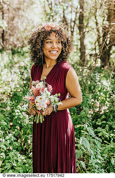 Woman standing in woods with fresh flowers and floral crown