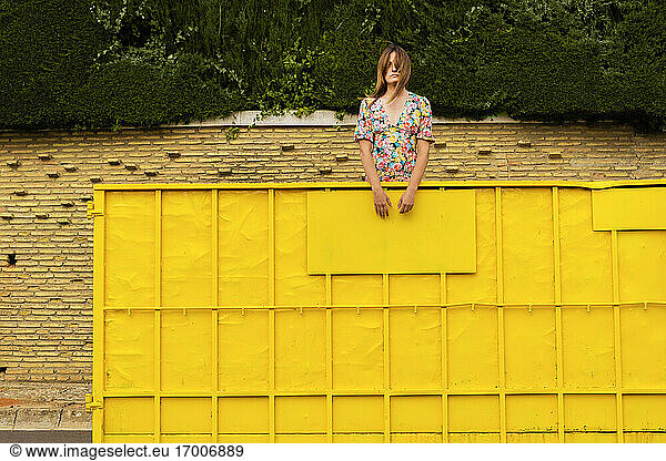 Woman standing in yellow container  looking around