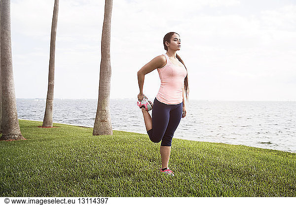 Woman standing on grassy field and exercising