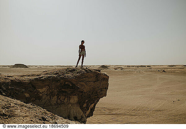 Woman standing on rock in desert