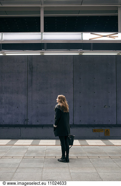 Woman standing on subway station platform