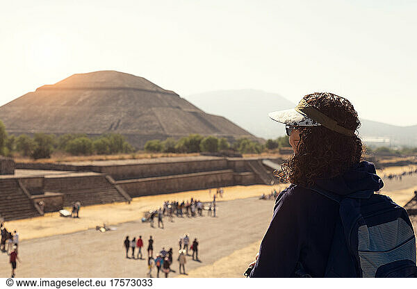 Woman staring at pyramids in Teotihuacan during sunrise