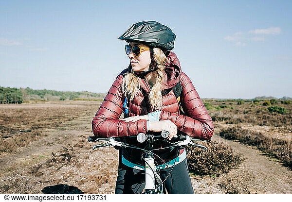 woman stood enjoying the sunshine whilst out mountain biking in the UK