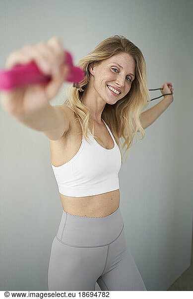 Woman stretching arms with skipping rope