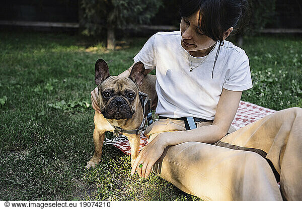Woman stroking dog in park