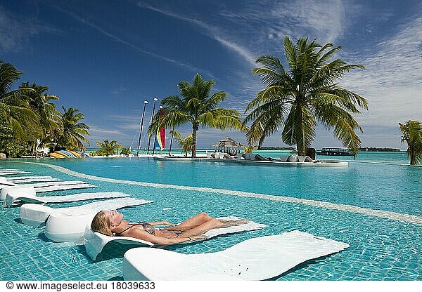 Woman sunbathing at pool  Kandooma Island  South Male Atoll  swimming pool  pool  sun lounger  Maldives  Asia