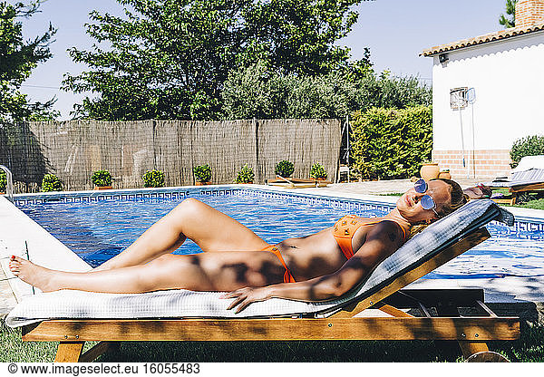 Woman sunbathing at swimming pool