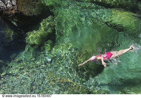 Woman swimming in refreshing Verszasca river