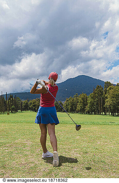 Woman swinging club while playing golf at golf course  Bedugul  Bali  Indonesia