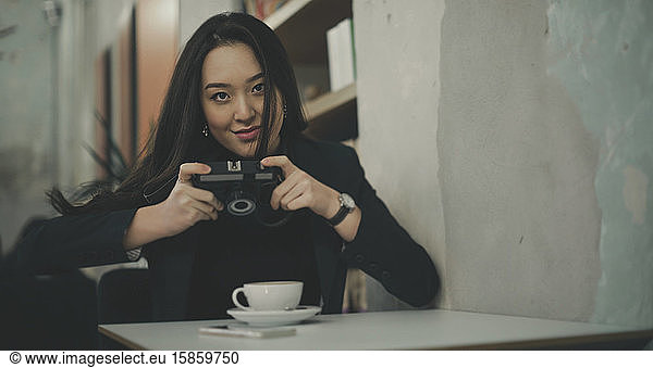 woman take a picture with a vintage camera