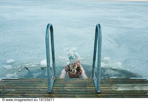 woman taking a dip in the frozen Baltic Sea in Scandinavia
