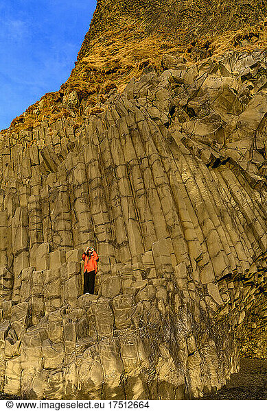 Woman taking a photo at Reynisfjara beach  Iceland