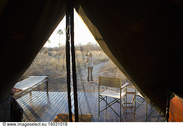 Woman taking a photograph at dusk  in the Kalahari Desert.