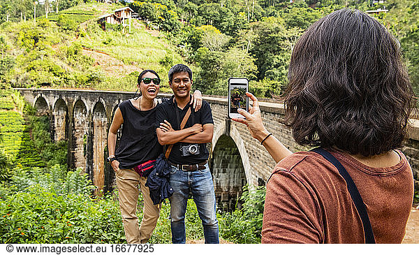 woman taking a picture of her friends at the iconic Nine Arch Bridge