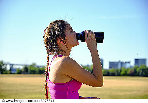 Woman taking a water break during workout