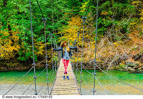 Woman taking in the scenery while crossing a bridge in Mount Rainier National Park  Washington State  United States of America  North America