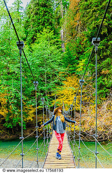 Woman taking in the scenery while crossing a bridge in Mount Rainier National Park  Washington State  United States of America  North America