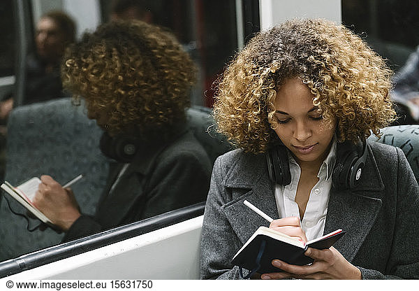 Woman taking notes on a subway