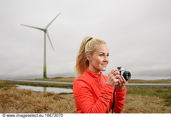 Woman taking photos near windmill