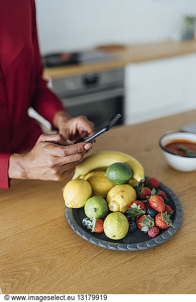 Woman taking pictures of fruits on a plate