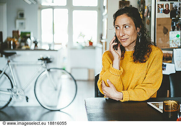 Woman talking on smart phone sitting at home