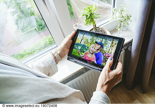 Woman talking on video call with granddaughter through tablet PC