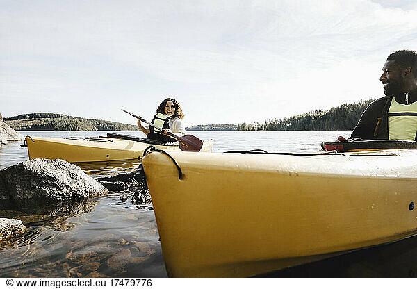 Woman talking with boyfriend while kayaking on lake