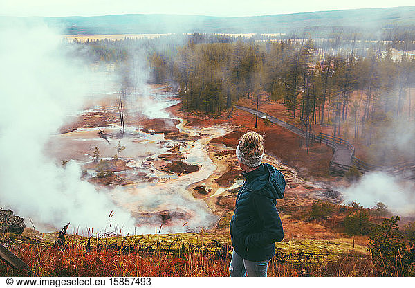 Woman tourist overlooking geyser at Yellowstone National Park