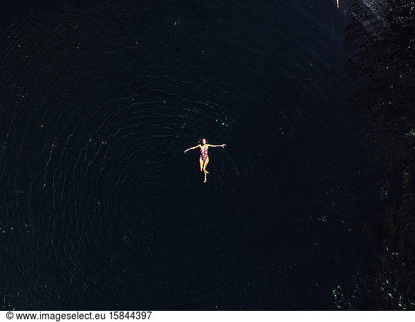 Woman tourist swimming in clean water of Cenote Crystal