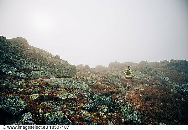 Woman trail running in fog on NH's Presidential Traverse