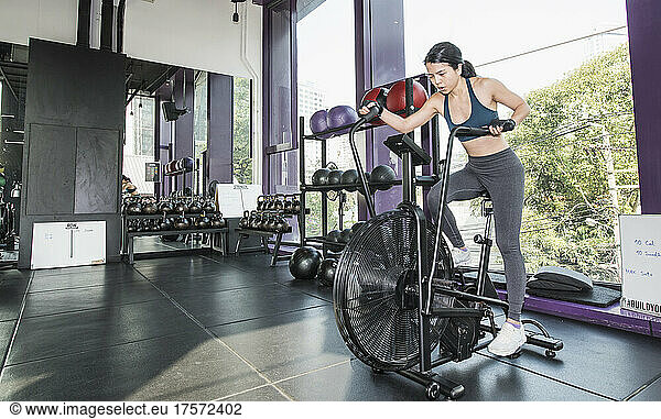 woman training on exercise bike at gym in Bangkok