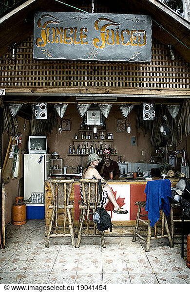 Woman traveler and bartender smile at the beach side bar Jungle Juiced  Sosua  Dominican Republic