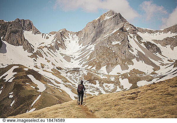 Woman trekking towards snowy mountains