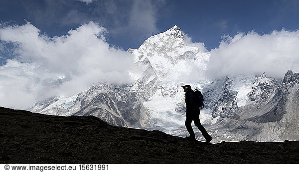 Woman trekking with Mt Everest  Nuptse and Kala Patthar in background  Himalayas  Solo Khumbu  Nepal