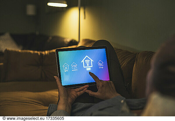 Woman turning on wifi through digital tablet at home