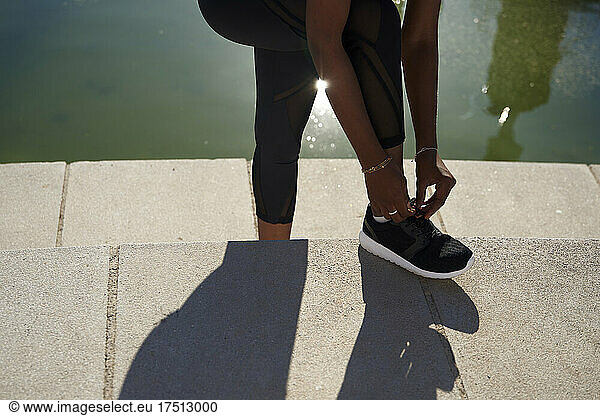 Woman tying shoelace of her black shoe