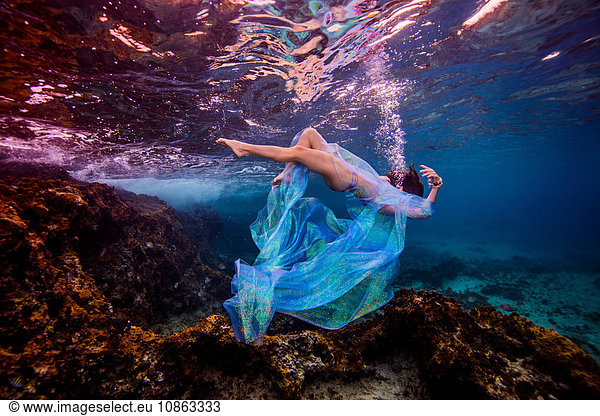 Woman underwater in ocean over coral reef