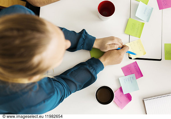 Woman using adhesive notes during business meeting