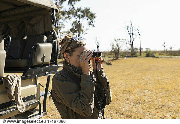 woman using binoculars Okavango Delta  Botswana