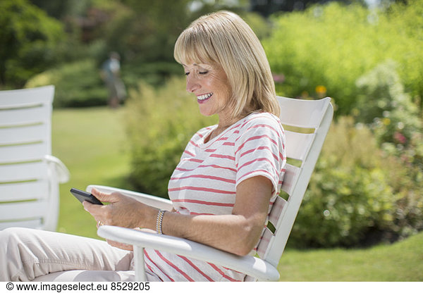Woman using cell phone in garden