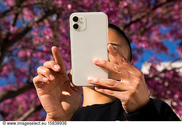 woman using cell phone outdoors in springtime