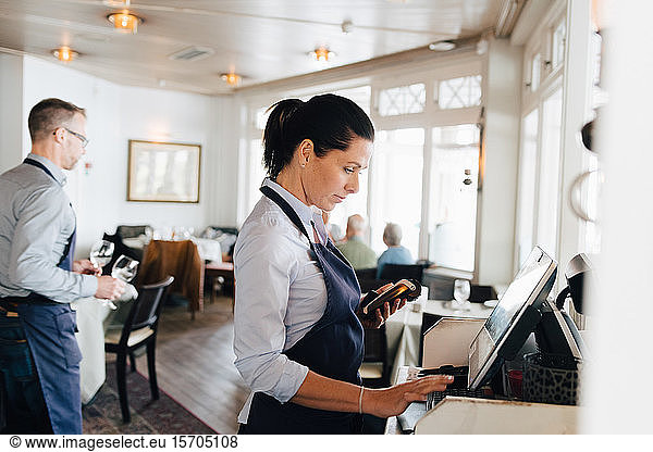 Woman using computer in restaurant