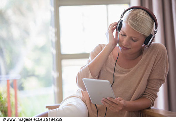 Woman using digital tablet and headphones