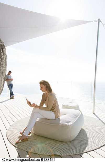 Woman using digital tablet on modern balcony