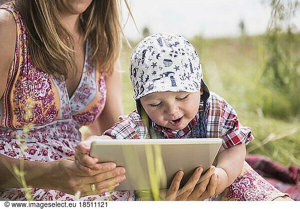 Woman using digital tablet with her little son in the countryside  Bavaria  Germany