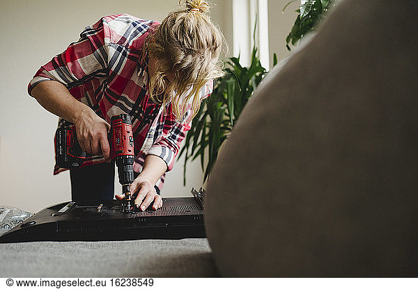 Woman using electric screwdriver