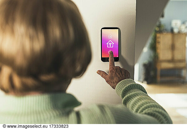 Woman using futuristic home automation device on wall