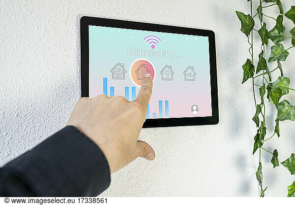 Woman using home automation device on wall